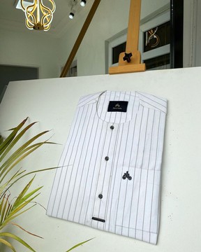 Un caftan sur mesure pour hommes à rayures noires et blanches avec des détails de boutons noirs.