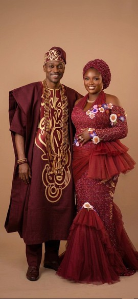 Ensemble assorti pour couple comprenant un agbada bordeaux brodé d’or et une robe de soirée sirène à motifs floraux