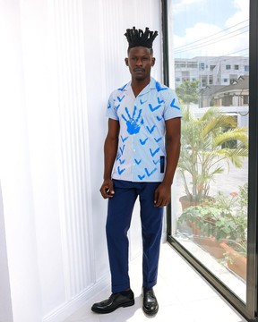 Une chemise à rayures blanches et bleues à motifs peints à la main.