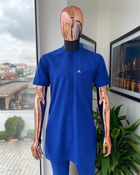 Un rabat avant bleu cobalt avec une poche plaquée détaille le caftan traditionnel africain du sénateur