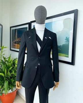 Un costume « power » fendu à l'avant et à l'arrière, noir anthracite, long revers en pointe à bretelles croisées