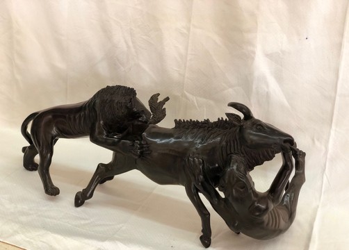 Sculpture en bois d’ébène représentant un lion attaquant un buffle, pièce saisissante et rare, chef-d’œuvre de décoration intérieure