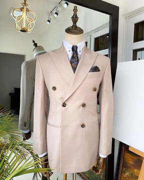 Un costume à revers croisé crème irlandaise avec des boutons roulants en corne marron foncé.