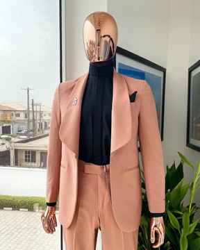 Un costume de smoking à revers châle mauve, une chemise noire à col Bishop et un pantalon pantalon.