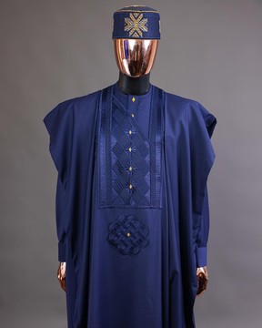 Un cube incliné bleu marine avec des détails dorés en pointillés agbada, buba, fila et sokoto
