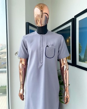 Une poche à volants rembourrée gris argenté détaillant le caftan de sénateur traditionnel africain natif.