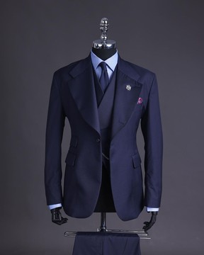 Un costume bleu marine en tricot à revers cranté, un manteau à double boutonnage et un pantalon.