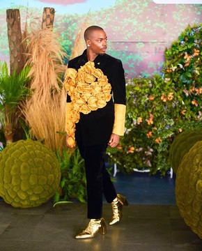 Un blazer en velours noir anthracite avec des pétales de soie dorées.