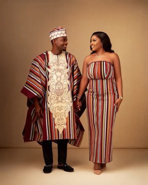 Ensemble assorti pour couple composé d’un agbada rayé en Aso Oke et d’une longue robe bustier