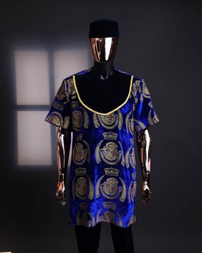 An “isiagu” gold, blue with matching fringe details, short sleeve, hat &amp; velvet pant African Native