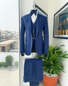 Un motif à carreaux, un revers en pointe, un costume à 2 boutons, un pantalon, un gilet classique et un nœud papillon.