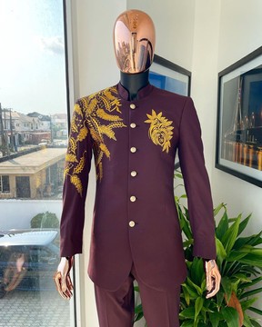 Un saharienne bordeaux avec des broderies à motifs floraux dorés et un pantalon pantalon.