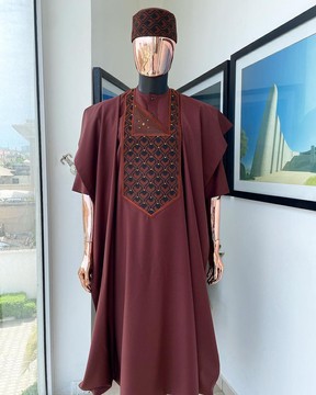 Un agbada brun cannelle, des détails de broderie d'aubergines superposées, un chapeau et un natif traditionnel Swarovski