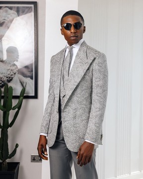 Un costume à revers en pointe en jacquard floral gris clair et noir, une cravate et un pantalon.