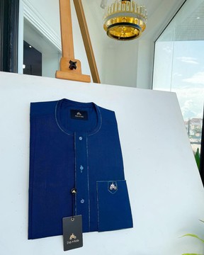 Un bleu égyptien, rabat sur le devant, poche plaquée, boutons Swarovski assortis, caftan à détails cachemire