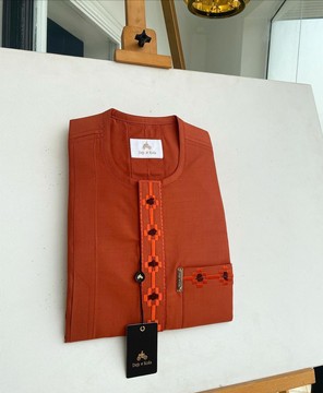 Un kaftan de sénateur traditionnel africain orange feu, rabat et poche avant ondulant.