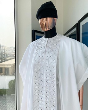 A white, connected square embroidery design with matching agbada