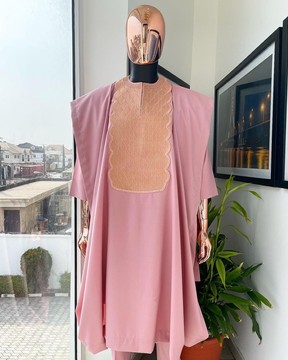 Une broderie en spirale monochrome rose flamant détaillant l'agbada