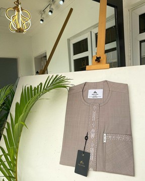 A light lilac senator kaftan with a dispersed connected embroidery design.