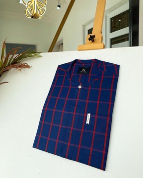 Un caftan sur mesure pour homme à carreaux bleu marine et rouge.