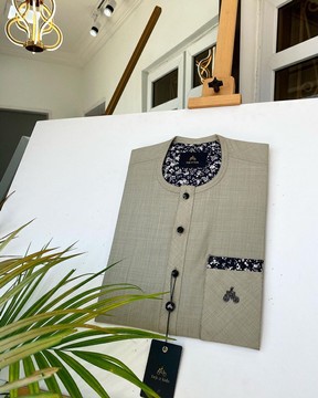 Un caftan irlandais marron avec une poche et des boutons en pierre Swarovski.