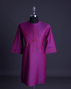 Un tissu magenta à chevrons, des détails de broderie en anneau interconnectés, des détails de caftan de sénateur africain natif.