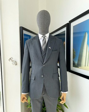 Un costume gris à revers en pointe à rayures crayon, un manteau à double boutonnage à revers cranté