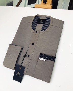 A tailored Irish carton color kaftan with black swarovski button detailing on flap and pocket.