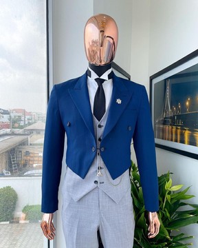 Un tailleur bleu marine, un gilet classique gris clair, une cravate tissée noire et un pantalon.