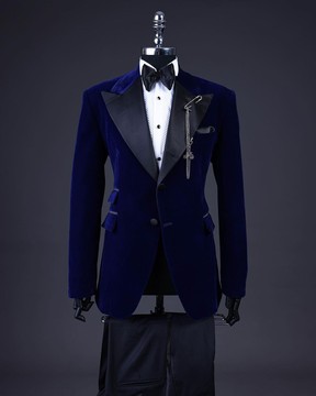 Un costume de smoking bleu marine en velours trempé, revers en pointe et ceinture de smoking, un nœud papillon et un pantalon de smoking