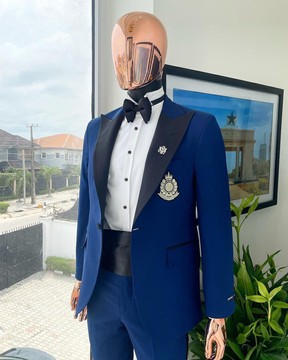 Un revers en pointe "classique", un costume de smoking bleu marine, une ceinture, un pantalon et un nœud papillon