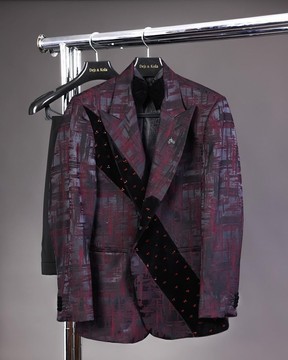 Une coupe diagonale en velours noir superposé Swarovski détaillant un costume à motifs éclaboussés bordeaux et noirs