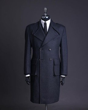 Un trench-coat gris plomb, à double boutonnage, à revers cranté avec poche de combat.