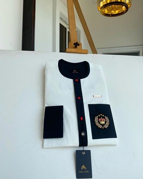 An Ivory white kaftan with black flap, pocket &amp; cuff.