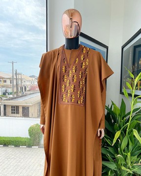 Un agbada brun fauve, un mélange de motifs d'ailes et de broderies dorées, un sokoto et un caftan
