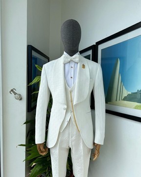 An ivory white, elastic, basket weave layered floral jacquard shawl lapel tuxedo suit &amp; floral pant.
