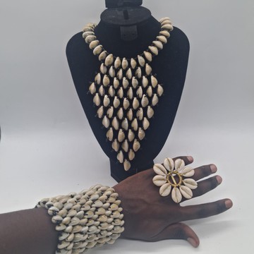 Ensemble de bijoux en coquillages cauris faits main : collier plastron, bracelet manchette large et bague fleur en laiton.